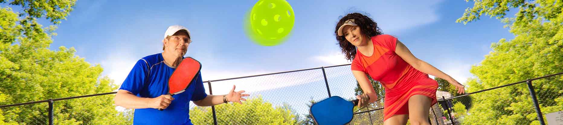 adult group tennis class with coach teaching beginning level ladies how to play tennis